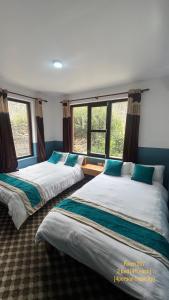 two beds sitting in a room with windows at Hotel Marpha Comfort And Restaurant in Tukucha