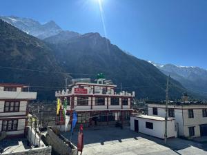 a large building with mountains in the background at Hotel Marpha Comfort And Restaurant in Tukucha