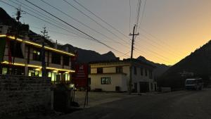 a building on the side of a street with the sunset at Hotel Marpha Comfort And Restaurant in Tukucha