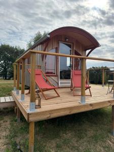 a tiny house with two chairs on a wooden deck at Chambre Panoramique Bellevue in Bellegarde-Adoulins