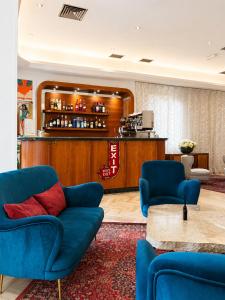 a lobby with two blue chairs and a bar at Hotel Columbia Frontemare in Rimini