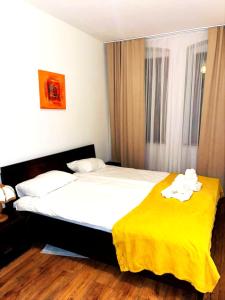 a bedroom with a bed with a yellow blanket at EBRAM II Apartments Görlitz in Görlitz