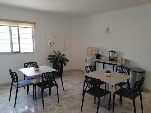 two tables and chairs in a room with a kitchen at Casa RyS Hotel in Ocotlán