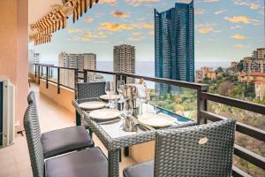 a balcony with a table and chairs with a view of the city at Monte Carlo Monaco Border, Swimming Pool, Parking, See View, Terrace in Beausoleil