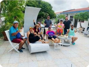 a group of people posing for a picture on a patio at Hostel WAIVING MILL in Oranjestad +2 photos