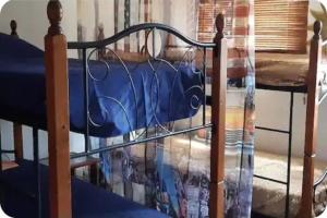 a bed with a blue bed frame and a table at Hostel WAIVING MILL in Oranjestad