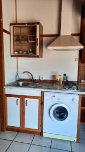 a kitchen with a washing machine and a sink at Chalet Saint Julien en Born in Saint-Julien-en-Born