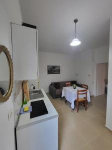 a kitchen and a living room with a table at Oliver Studios in Ksamil +18 photos