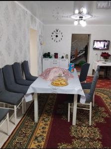 a dining room with a white table and chairs at Keremet house in Barskoon