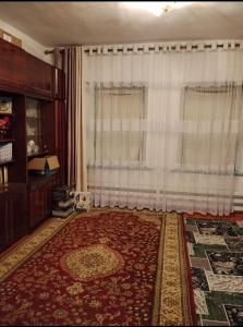a living room with a large rug and a window at Keremet house in Barskoon