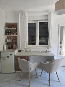 a kitchen with a table and two chairs and a refrigerator at Studio apartman Carera Deluxe in Vinkovci