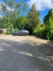 a car parked on a brick road with trees at EBRAM II Apartments Görlitz in Görlitz
