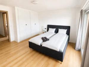 a bedroom with a large bed with white sheets at Bright Lake-View Apartment in Montreux