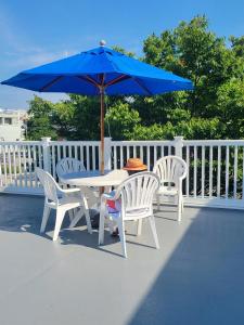 a table with two chairs and a blue umbrella at Atlantis Inn in Rehoboth Beach +7 photos