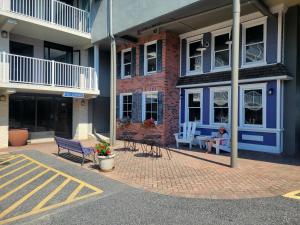 a woman sitting on a bench in front of a building at Atlantis Inn in Rehoboth Beach