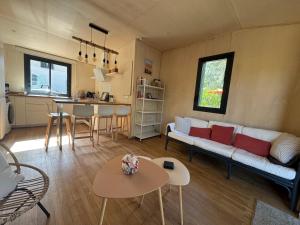 a living room with a couch and a table at N&L Signature - Ô Lodge in Mornas