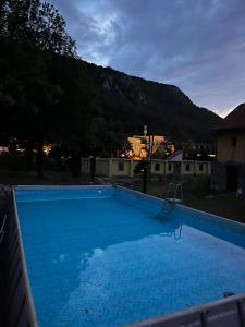 a large blue swimming pool with a mountain in the background at Musical Pansion Radgost, Rtanj in Rtanj