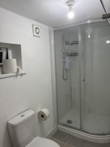 a white bathroom with a shower and a toilet at Coventry Escape in Longford