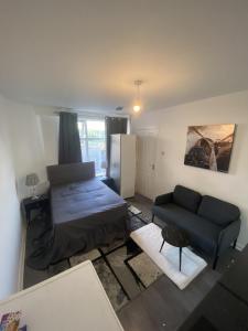 a living room with a bed and a couch at Coventry Escape in Longford