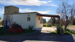 a small white building with a roof at APA Las Condalias in Puerto Madryn