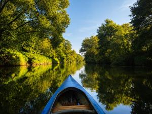 a boat on a river with trees in the water at maringotka Hedvika glamping in Pašice +1 photo
