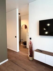 a living room with a television on a wall at AC Central Station apartments in Daugavpils