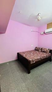 a bedroom with a bed in a pink room at Radha krishna in Vellore