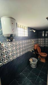 a bathroom with a toilet and a bucket in it at Radha krishna in Vellore