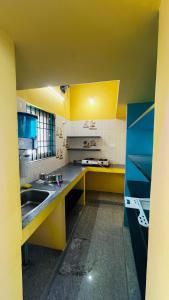 a kitchen with yellow cabinets and a sink at Radha krishna in Vellore