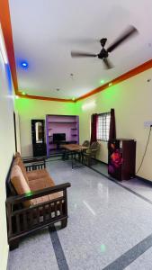 a living room filled with furniture and a ceiling fan at Radha krishna in Vellore