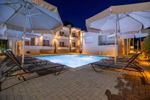 a swimming pool with two chairs and two umbrellas at Porto Dionysos in Ofrínion