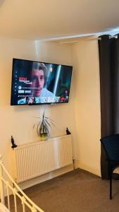 a flat screen tv hanging on a wall at Private Ensuite Room with Bay Window, Free Parking and Fast WiFi in Sheffield