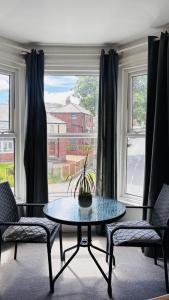 a room with a table and two chairs and a window at Private Ensuite Room with Bay Window, Free Parking and Fast WiFi in Sheffield