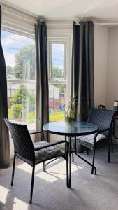 a table and chairs in a room with a window at Private Ensuite Room with Bay Window, Free Parking and Fast WiFi in Sheffield