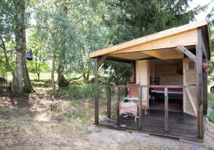 a wooden shed with a table and a chair in a field at Cottage in Remízek in Havlíčkŭv Brod