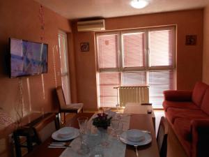 - un salon avec une table et un canapé dans l'établissement Апартамент Мур, à Sofia