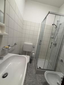 a white bathroom with a shower and a sink at Marghita La Salle in La Salle
