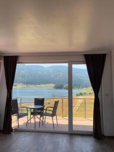 a balcony with a table and chairs and a view of a lake at Complex Forest Sarnitsa in Sarnitsa