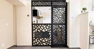 a black door with a geometric design on it at Park and Fly Belgrade Airport Apartments in Surčin