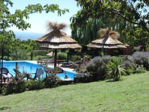 une piscine avec des parasols et une cour dans l'établissement Antawara, à Merlo 29 autres photos