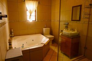 a bathroom with a tub and a toilet and a sink at Skilpadvlei Cottage and Studio's in Velddrif +27 photos