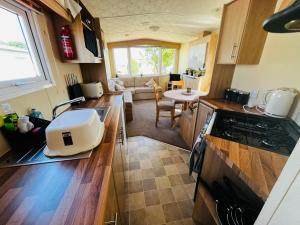 a kitchen with a counter top with a stove top oven at 22 seabreeze holiday park in Hemsby