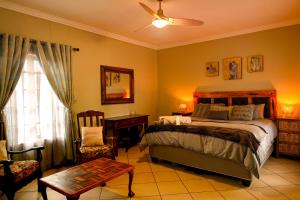 a bedroom with a bed and a chair and a window at Skilpadvlei Cottage and Studio's in Velddrif