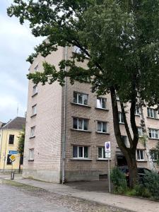 a large brick building with a tree in front of it at AC Central Station apartments in Daugavpils