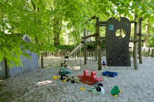 a playground with toys in the sand in front of a playground at Hovborg Kro in Hovborg