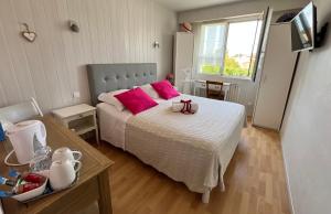 a bedroom with a large bed with pink pillows at Chambres d'hôtes La Rose Des Sables in Les Herbiers