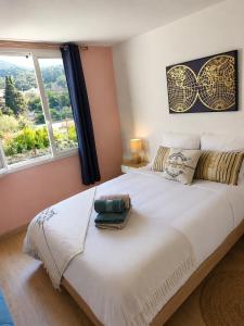 a bedroom with a large white bed with a window at Résidence du Soleil & Spa - Collioure in Collioure