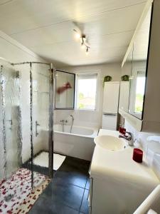 a white bathroom with a tub and a sink at Chambres d'hôtes La Rose Des Sables in Les Herbiers +38 photos