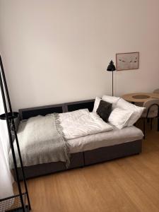 a bed in a room with a white wall at Apartament Mini Stary Sącz in Stary Sącz