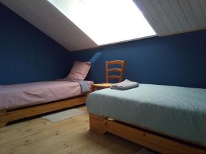 two beds in a room with a blue wall at Villa Signerose - chambres chez l'habitant au cœur de l'Ardèche - Hautes vallées in Le Cheylard
